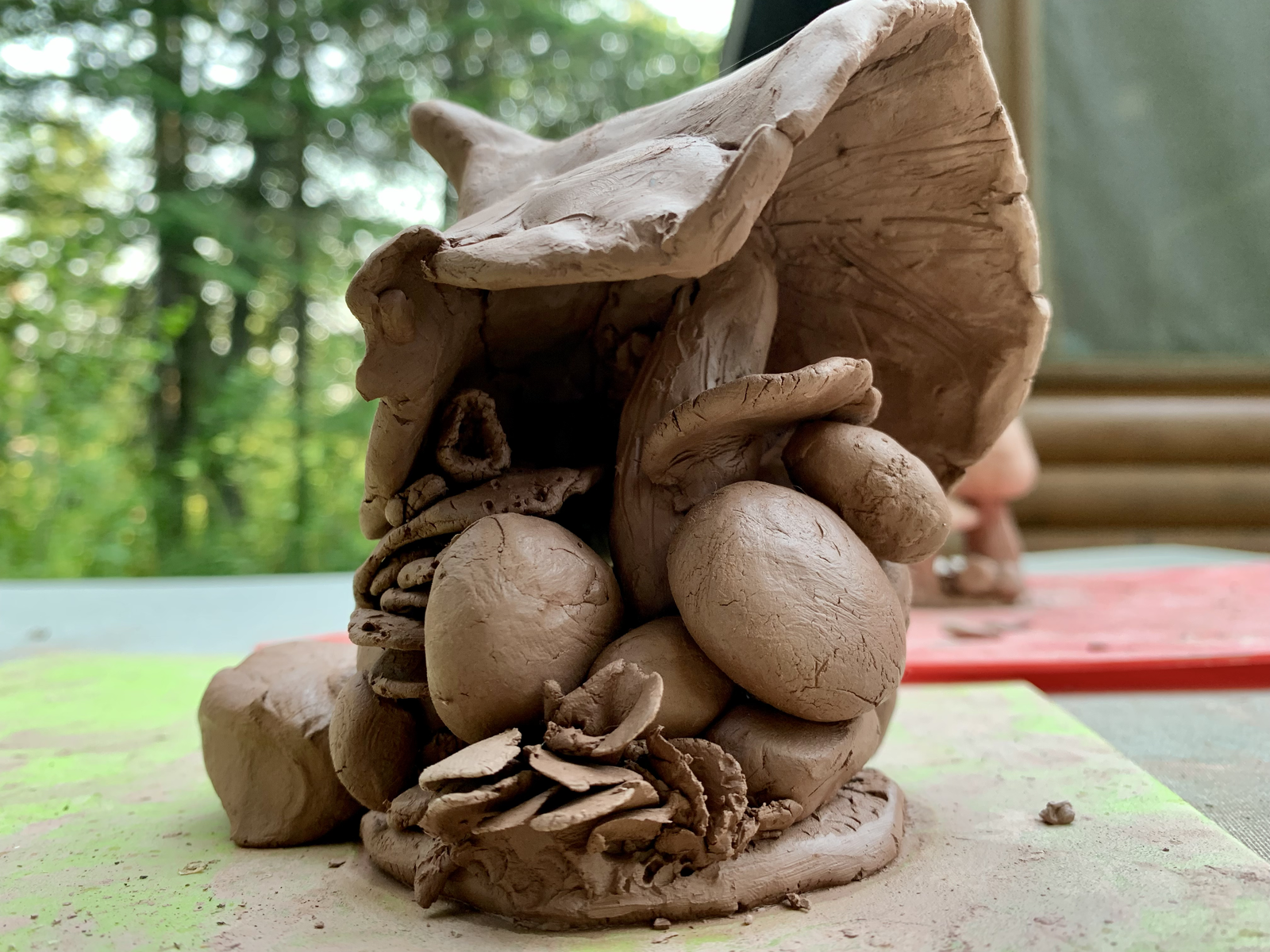 Clay mushroom sculpture from a different angle — showing the organic textures and clustered forms beneath the cap