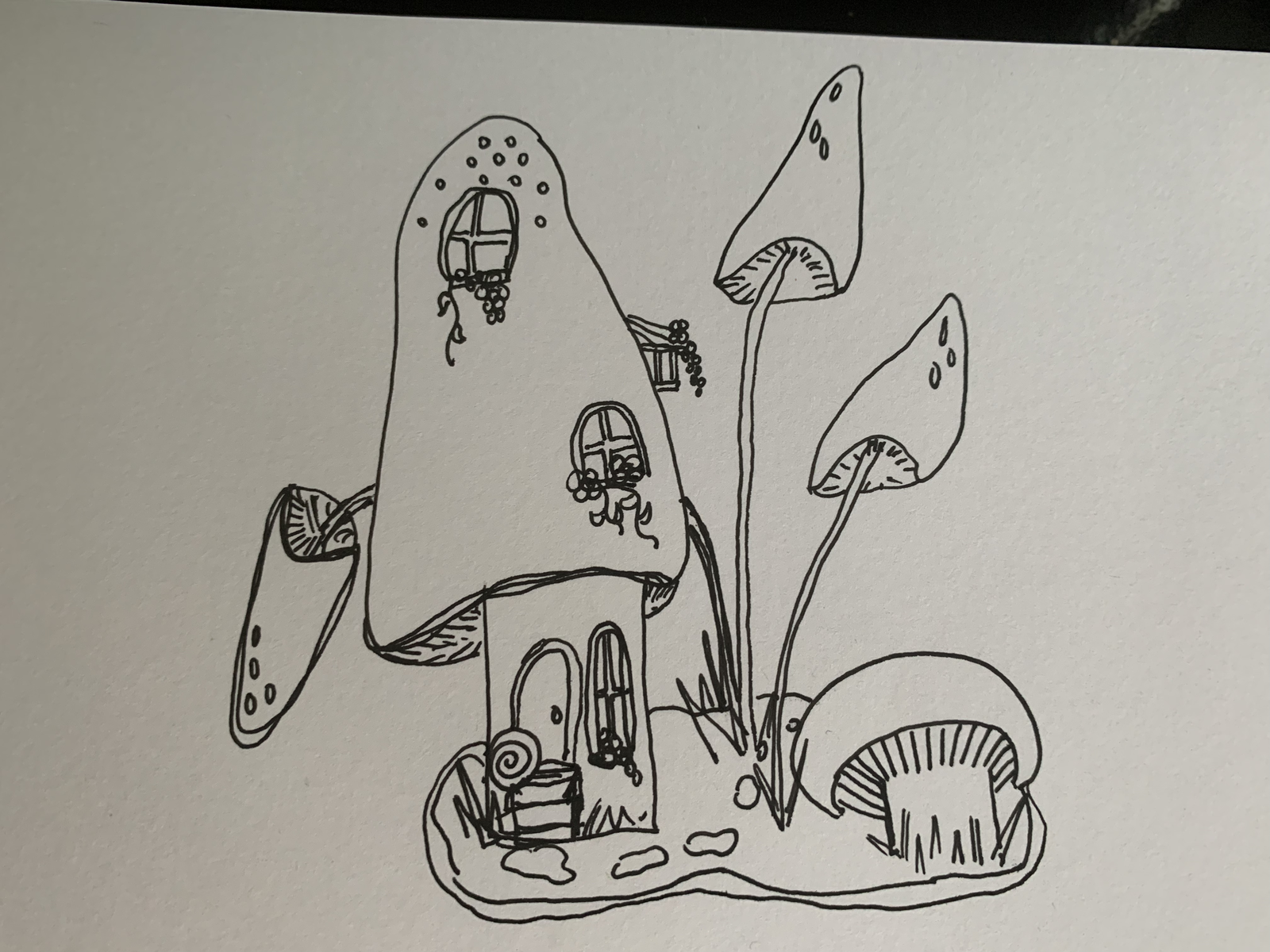Ink sketch of a mushroom village — whimsical toadstool houses with doors, windows, and surrounding smaller mushrooms