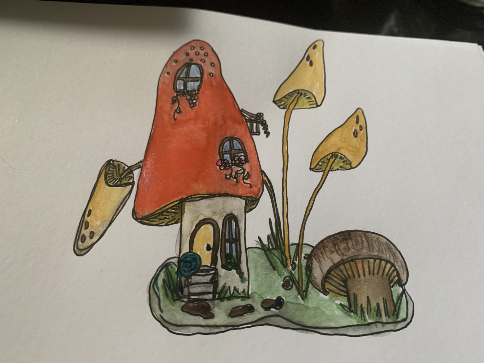 Watercolour painting of a mushroom house — red-capped toadstool with windows, a front door, snail, yellow mushrooms, and a brown toadstool on a grassy base