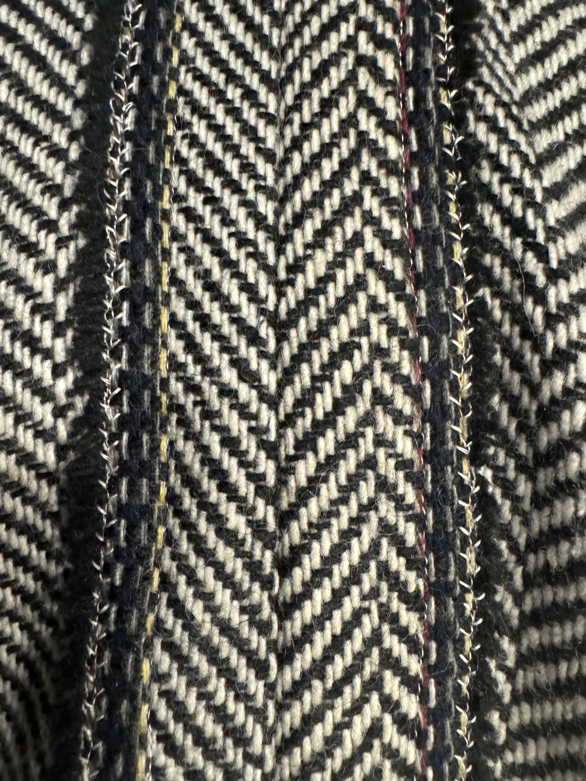 Close-up of herringbone weave and hand-stitched seam detail on the Coyote Auntie cape