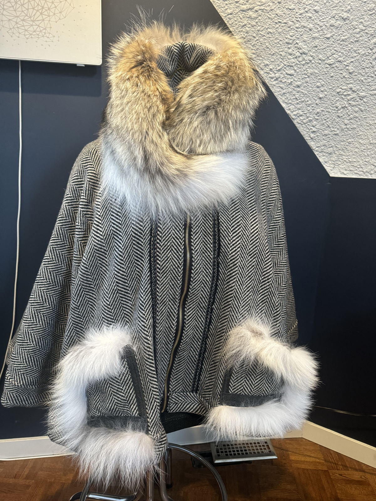 Pchi Loo Auntie cape with coyote fur hood and white fur pocket trim on herringbone wool