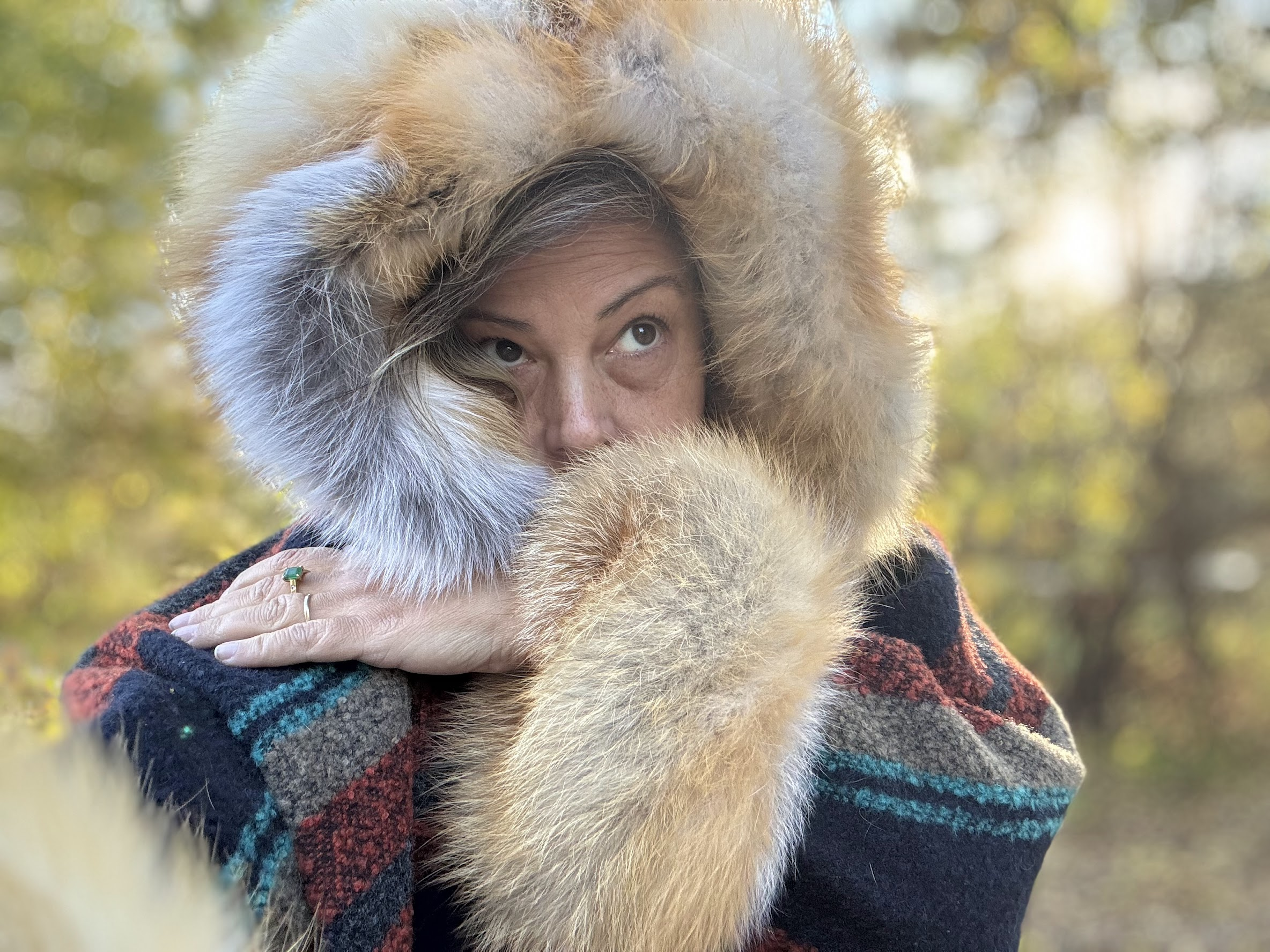 Marcella wearing an original fur-trimmed hood of her own design, outdoors in autumn light