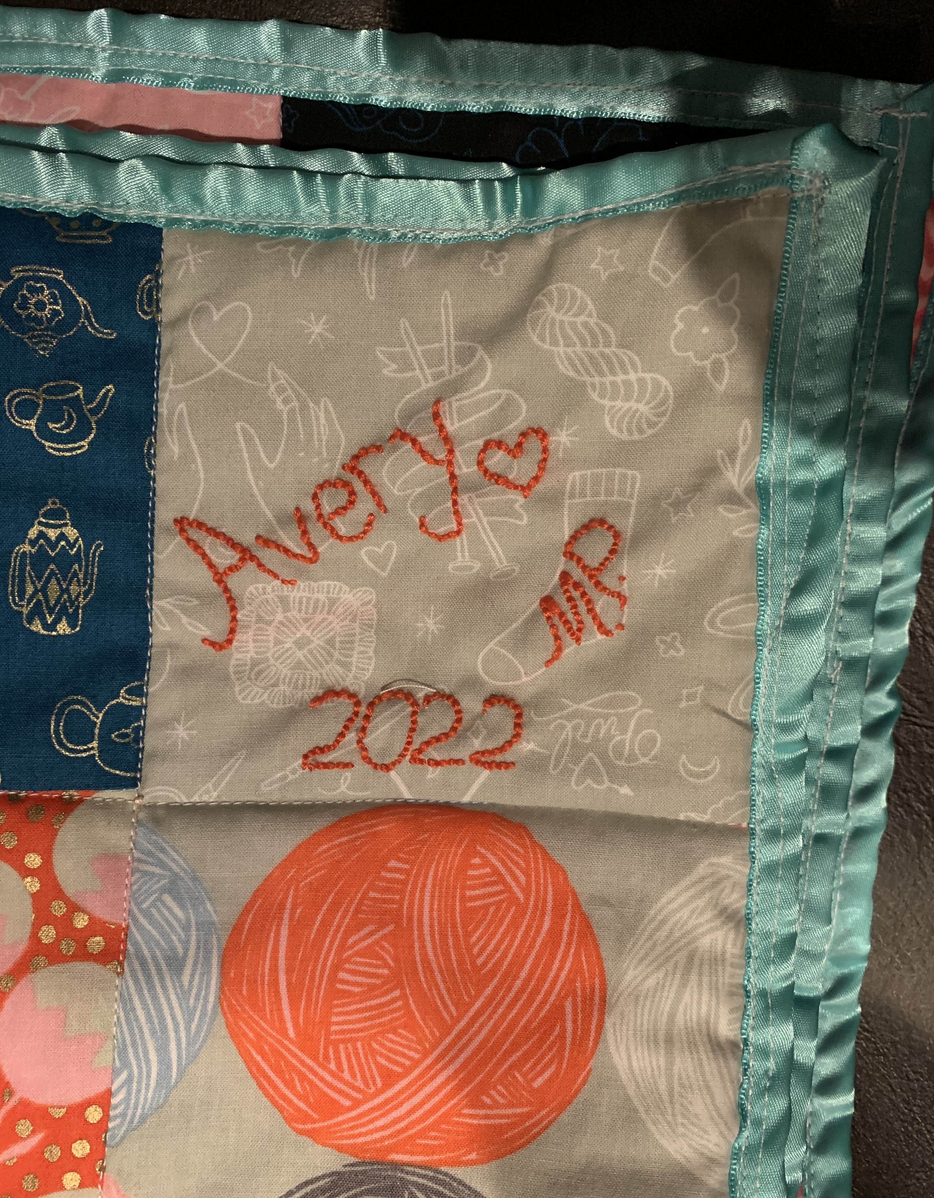 Little Fire quilt label — 'Avery ♥ M.P. 2022' embroidered in coral thread on grey fabric