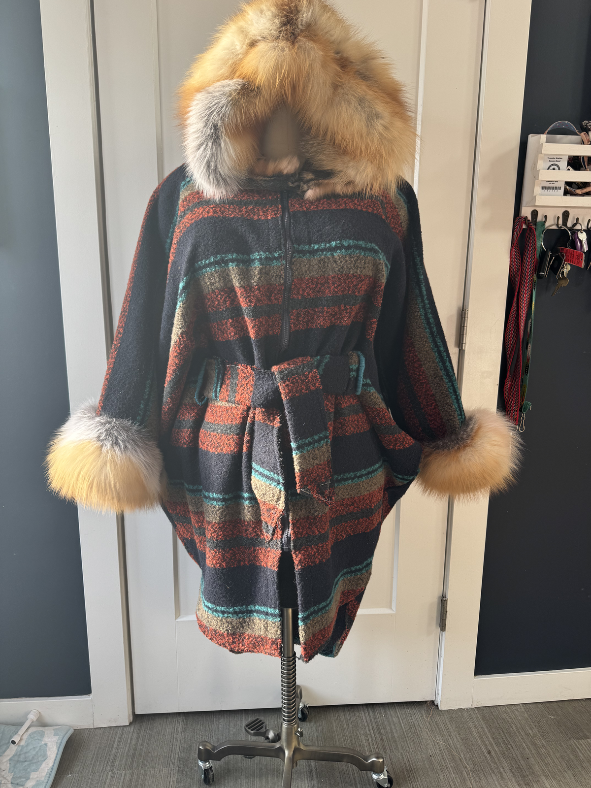 Mahkisis Auntie coat on dress form — striped wool with fox fur hood and cuffs, cinched waist