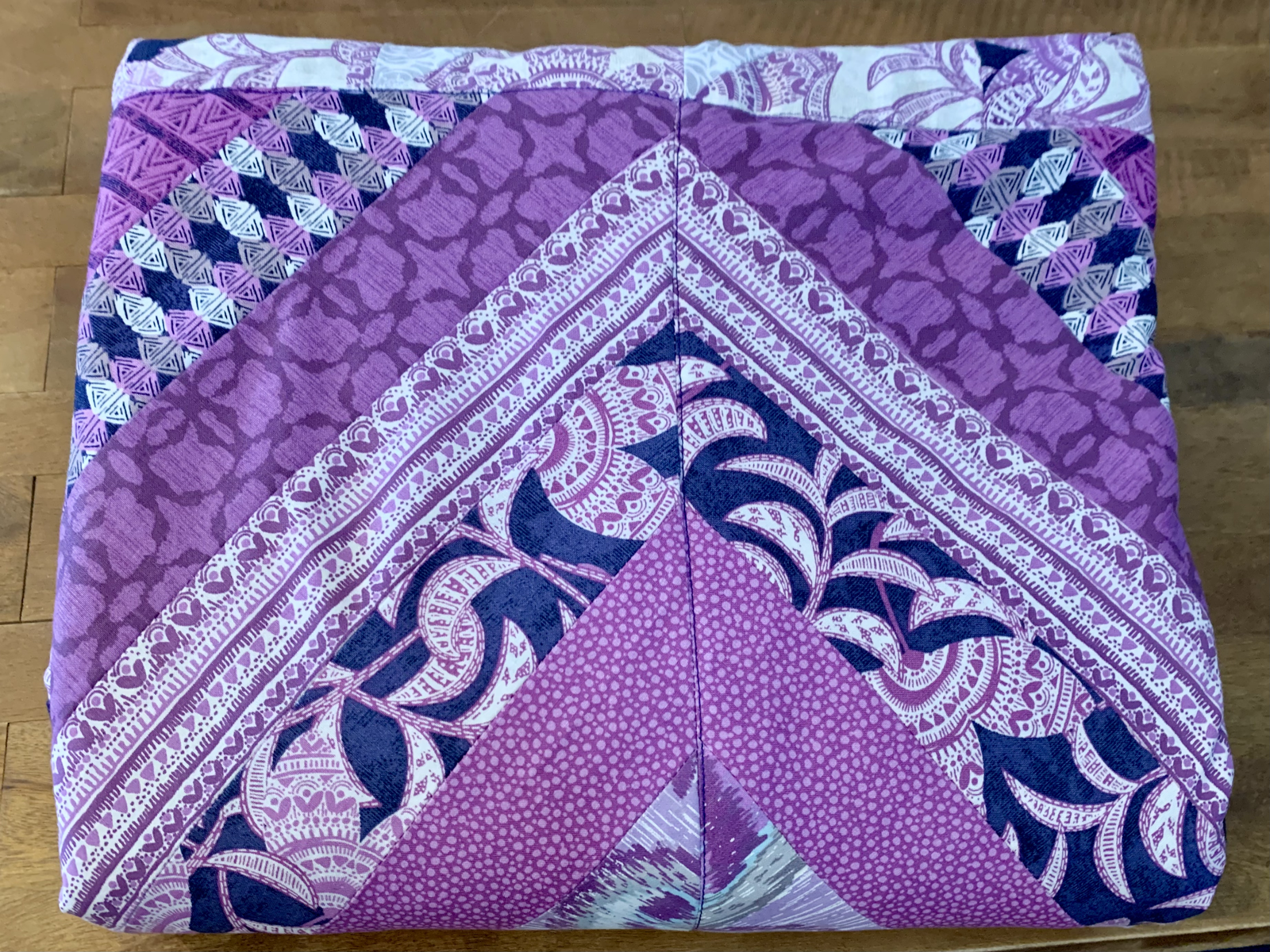 Purple Raining Prints quilt folded — chevron corner detail with deep purple, navy botanical, and pink dotted prints